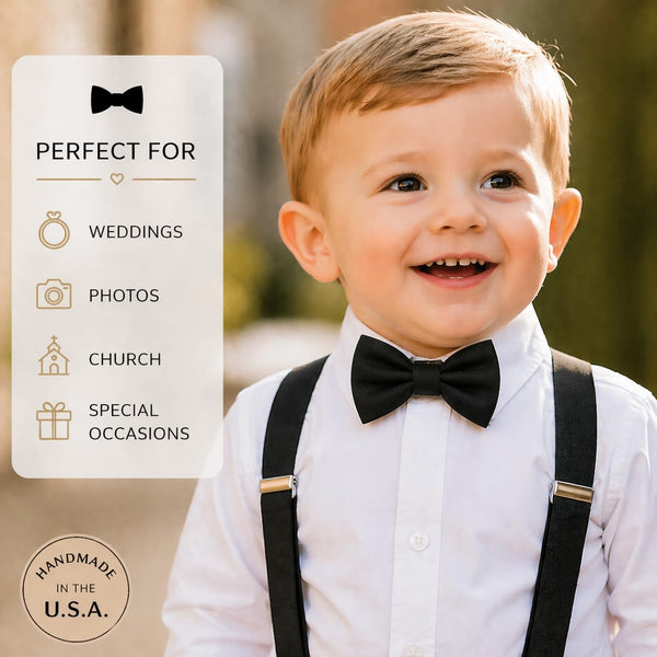 Smiling toddler boy wearing a black clip-on bow tie with white shirt and suspenders